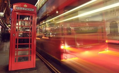 Phone booth with long exposure of bus next to it